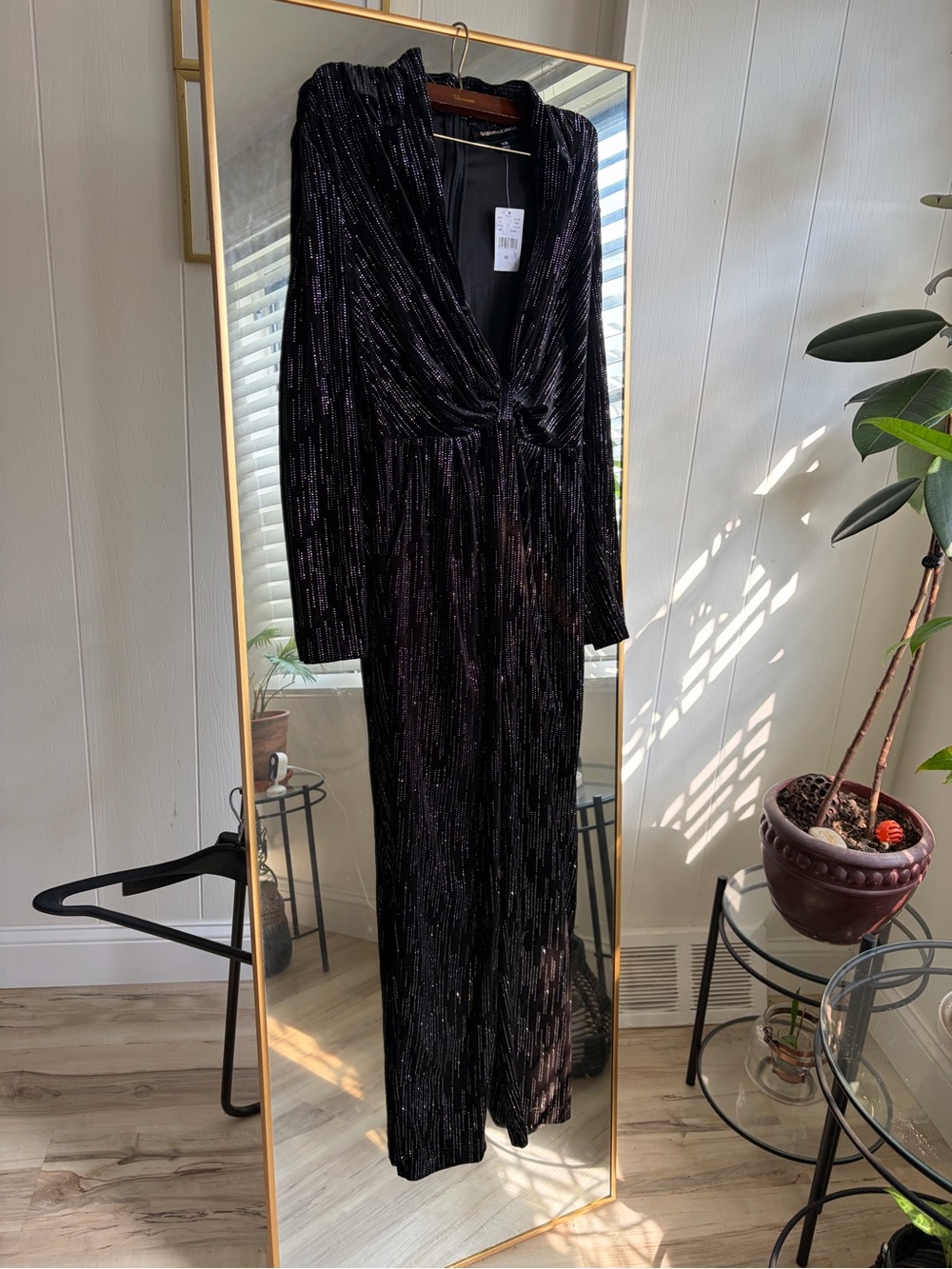 black, long-sleeve velvet jumpsuit with a plunging twist-front V-neck.